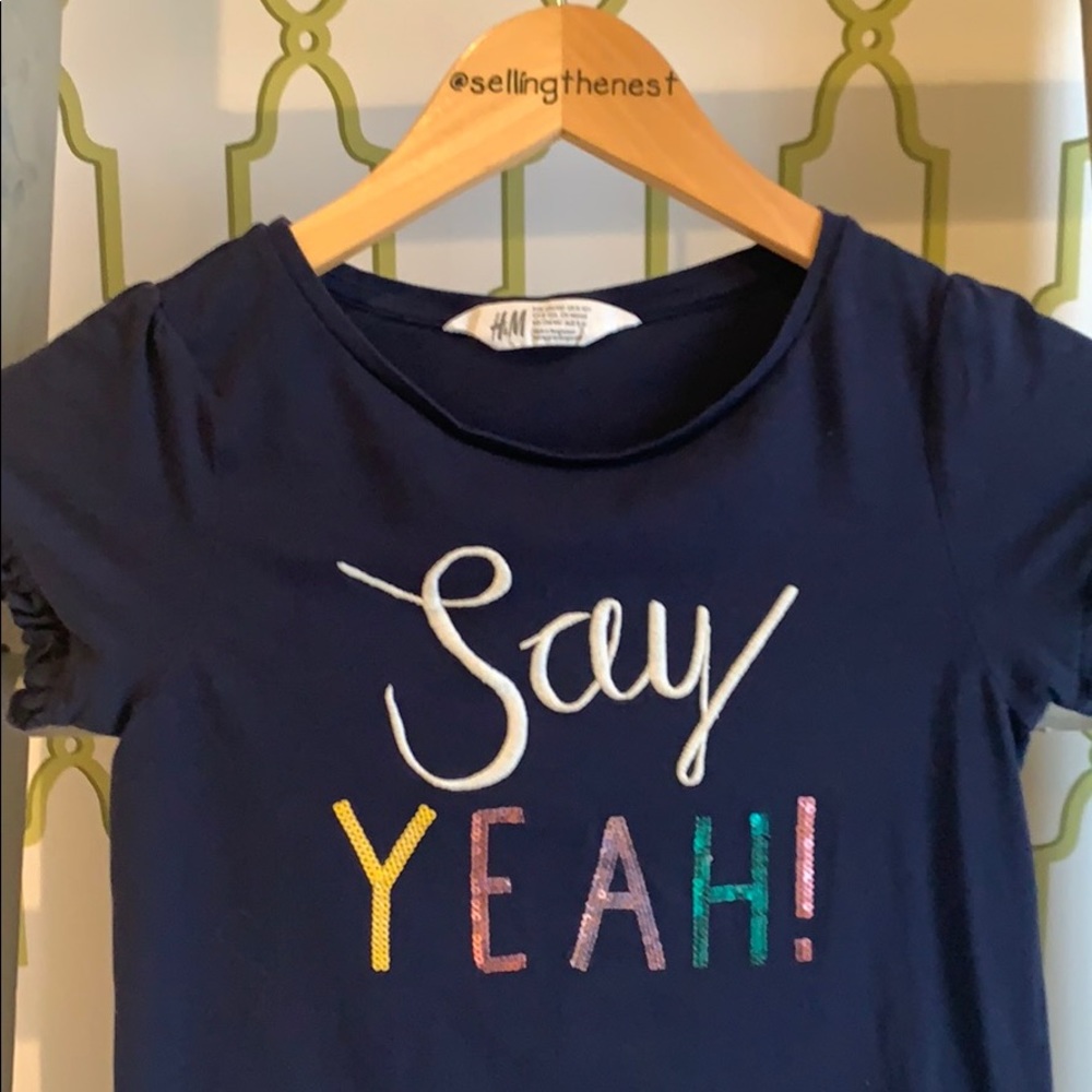 Girls navy shirt with the words “say yeah”.